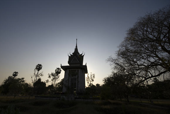 A Memorial Stupa located on the grounds of the Choeung Ek extermination camp is silhouetted at sunset in the outskirts of Phnom Penh February 9, 2009. The remains of nearly 9,000 people were exhumed in the 1980s from mass graves in this one-time orchard, also known as one of the 'The Killing Fields.'