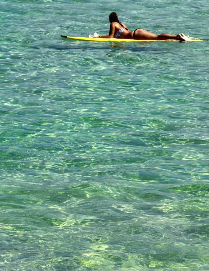A surfer waits for waves in the sea near Arpoador beach in Rio de Janeiro
