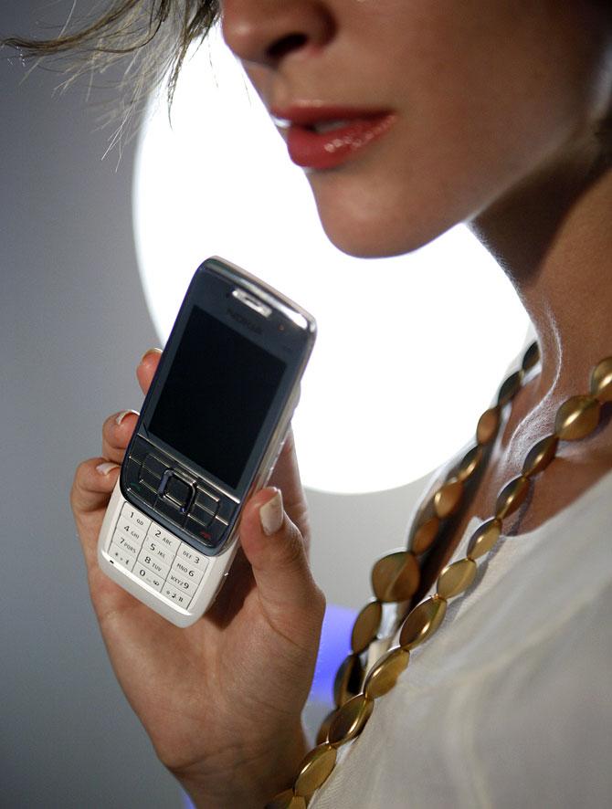 A model displays a Nokia E66 mobile phone for photographers at a launch event in Singapore June 16, 2008