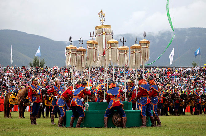 Mongolians place the Nine Flags during the annual Naadam Festival in Ulan Bator July 11, 2013. Naadam is the biggest event in the Mongolian calendar held from July 11 to 13, on the anniversary of the Mongolian revolution of 1921. Concerts, fairs and traditional sports like wrestling, archery and horse racing are held during the celebration.
