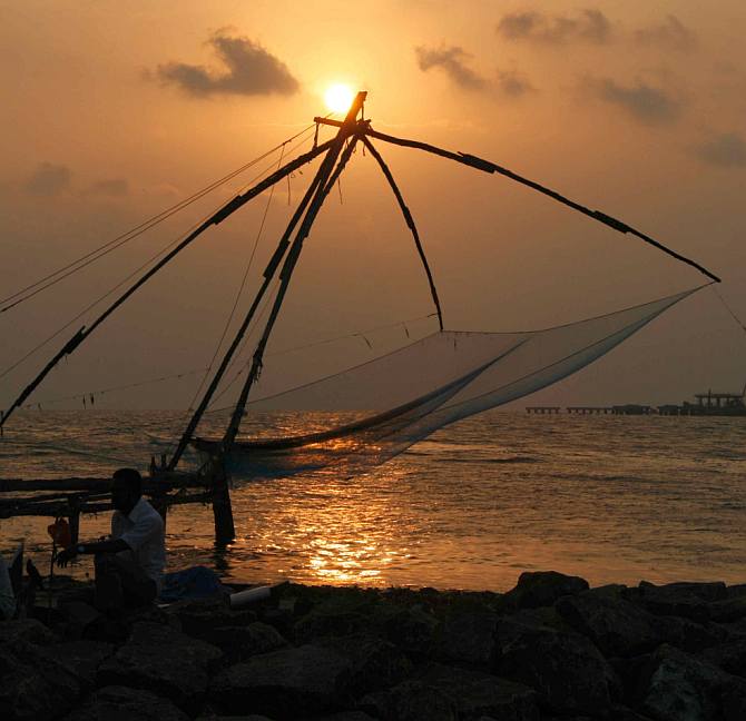 The sun sets over the Arabian Sea at Kochi even as the fishing nets sway in the wind