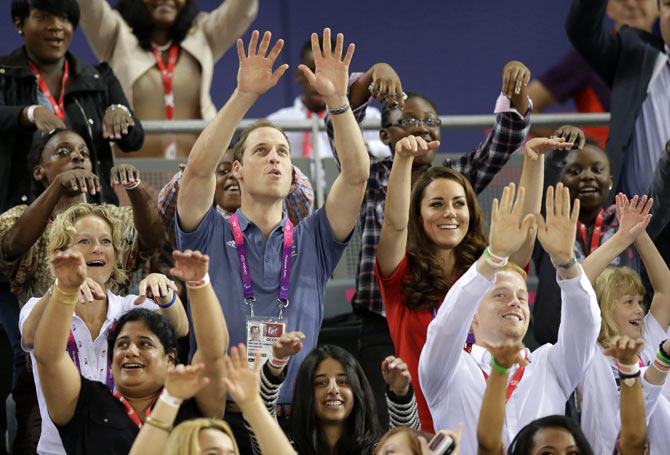 William and Kate participate in the Mexican Wave as they watch qualifying races during the London 2012 Paralympic Games.