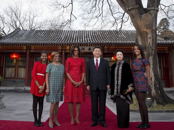 US first lady Michelle Obama, her daughters Malia (R) and Sasha (L)  and her mother Marian Robinson (2ndL) share a light moment with Chinese President Xi Jinping (C) and his wife Peng Liyuan (2ndR) after a photograph session at the Diaoyutai State guest house in Beijing, China