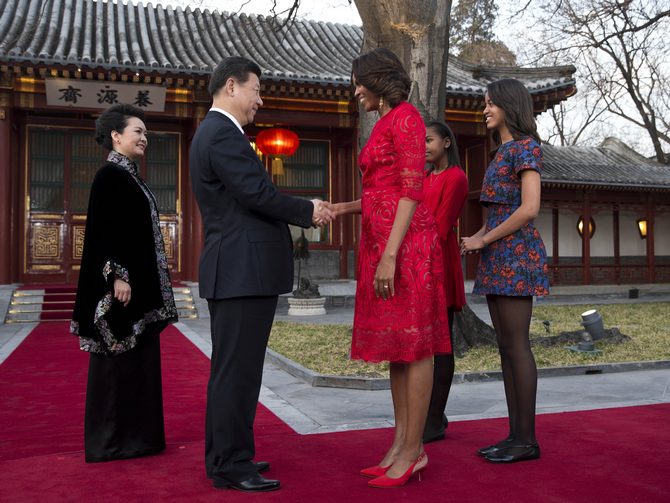 U.S. first lady Michelle Obama shakes hand with Chinese President Xi Jinping, as Michelle Obama's daughters Malia (R) and Sasha (2ndR) and Peng Liyuan, wife of Xi Jinping (L) look on before they proceed to a meeting at the Diaoyutai State guest house in Beijing, China.