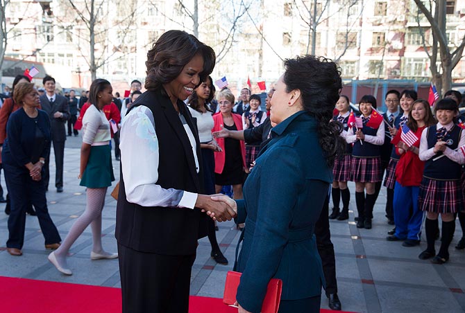 US first lady Michelle Obama and Peng Liyuan, wife of Chinese President Xi Jinping share a light moment during the former's week-long visit to China