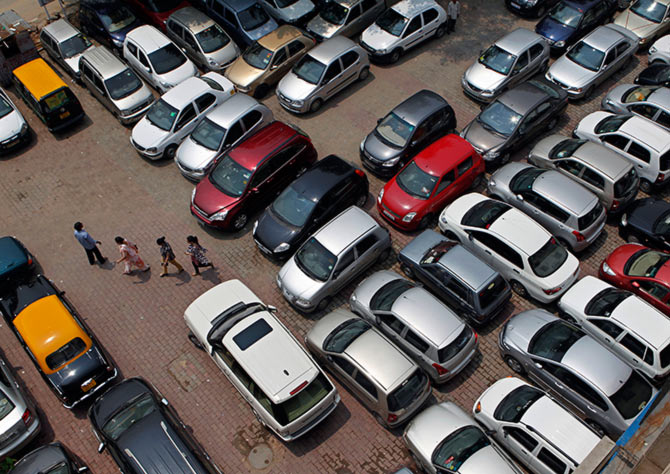 People walk through a car parking lot in New Delhi.
