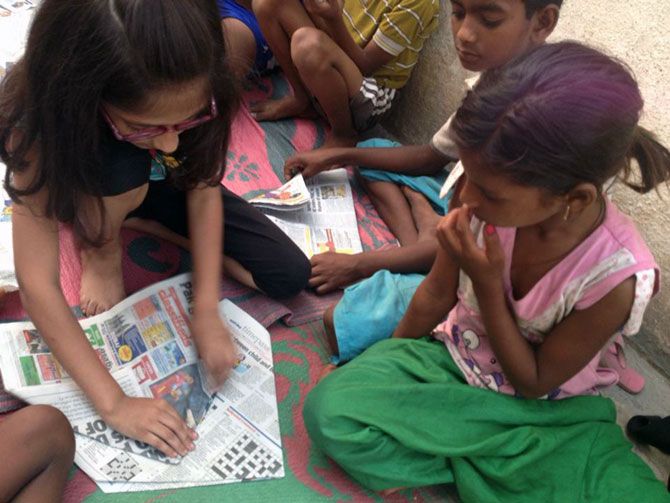 Ishita helps a young girl make paper rockets