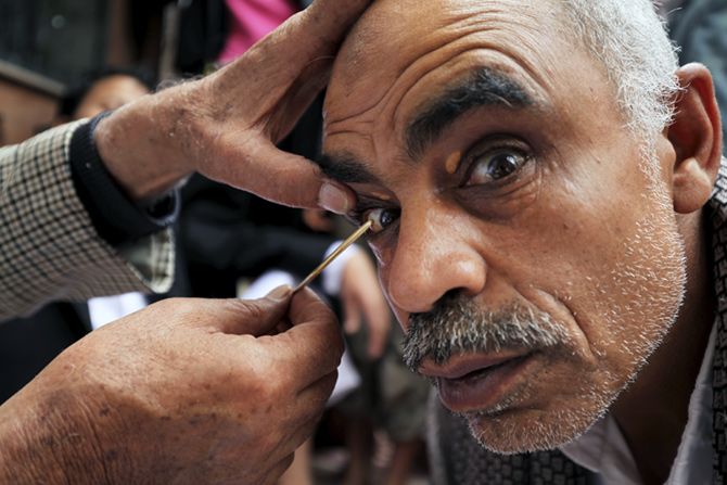 man applying kajal in his eyes