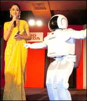 An Indian hostess looks at ASIMO (Advanced Step in Innovative Mobility), the first walking humanoid robot, as it shows its dancing skills in New Delhi on Monday on its first visit to India. ASIMO has been developed by the Honda Motor Company Ltd. Photo: Emmanuel Dunand/AFP/Getty Images
