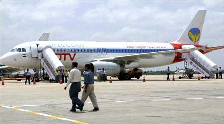 Airport employees walk past an Air Deccan Airbus A-320 aircraft before its flight to New Delhi at Bangalore Airport on Wednesday. Photo: Indranil Mukherjee/AFP/Getty Images