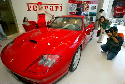 A Chinese model poses by a Ferrari sports car. Photo: Liu Jin/AFP/Getty Images