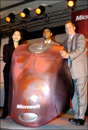 Director for Asia of the home and entertainment division of Microsoft Corporation, Jeff Hoffman (R), regional sales director for Asia and Greater China, Yolanda Chan (L), and the manager for Microsoft India Mohit Anand (C), pose for pictures with a model of the newly-launched Microsoft mouse in New Delhi on Monday. Photo/Prakash Singh / AFP / Getty Images