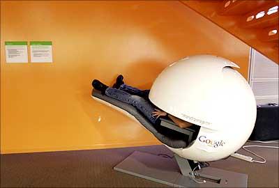 An employee takes a nap in a nap pod which blocks out light and sound at the Google headquarters in Mountain View, USA