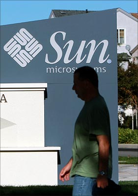 A pedestrian walks by a sign outside the Sun Microsystems headquarters in Santa Clara, California