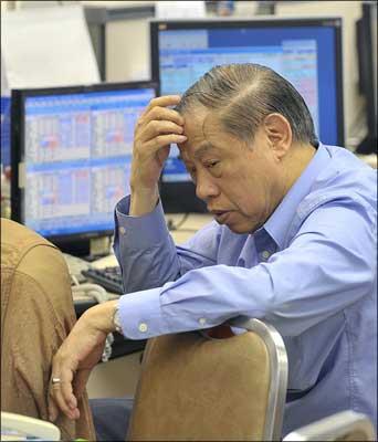 Traders monitor stock movements at a securities firm as share prices plummeted. | Photograph: Mike Clarke/AFP/Getty Images