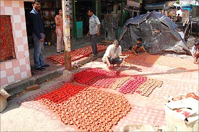 Workers make earthen lamps used to decorate Puja mandap.