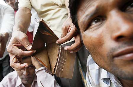 A worker shows his empty wallet.