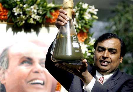 RIL Chairman Mukesh Ambani holds a jar containing the first crude oil produced from the KG-D6 block