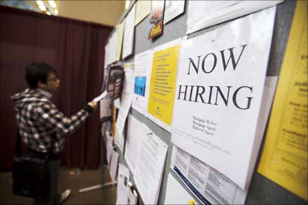 A man looks at a job board posted at a job fair. | Photograph: Mark Blinch/Reuters