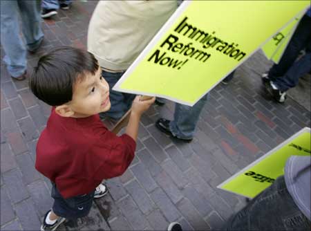A boy holds a sign as he walks during a May Day immigration and labor march and rally in downtown Los Angeles. | Photograph: Danny Moloshok/Reuters