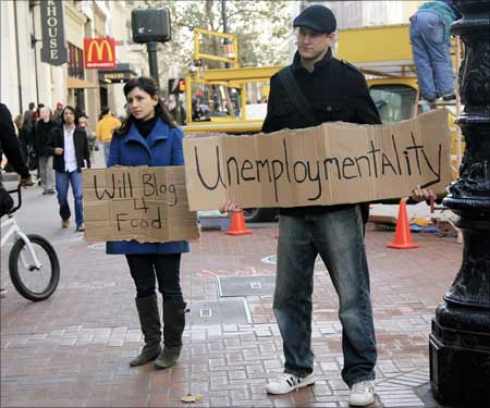 Tania Khadder (L), 29, and John Henion, 32, both unemployed online journalists, hold signs announcing a new blog called 'unemploymentality.com' along Market Street in San Francisco, California. | Photograph: Robert Galbraith/Reuters