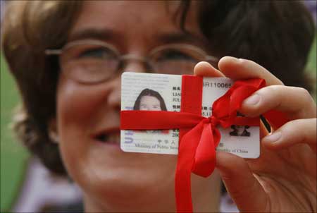 Julie Liang, originally from the United Kingdom, shows her 'green card' for permanent residency in the US. | Photograph: Claro Cortes IV/Reuters