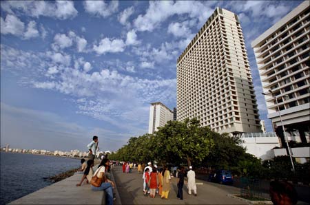 Tourists walk near the Oberoi Trident hotel in Mumbai