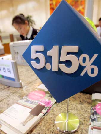 A South Korean bank clerk works next to a banner showing the bank's deposit rate in Seoul. | Photograph: You Sung-Ho/Reuters