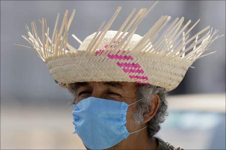 A man covers his face with a surgical mask in Mexico's city main square. | Photograph: Daniel Aguilar/Reuters