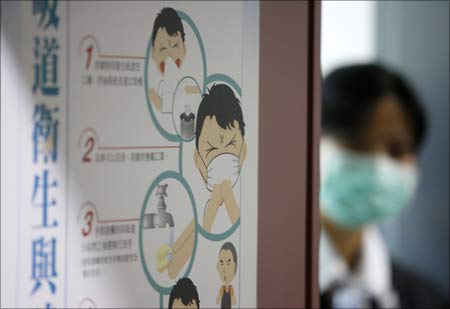 South Korean quarantine officers walk past a health sign at Incheon International Airport. | Photograph: Lee Jin-man/Pool