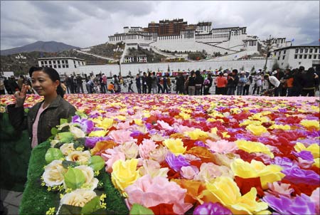 A tourist poses for a picture near the Potala Palace in Lhasa. | Photograph: China Daily/Reuters