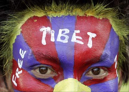 An exiled Tibetan with his face painted. | Photograph: Fayaz Kabli/Reuters