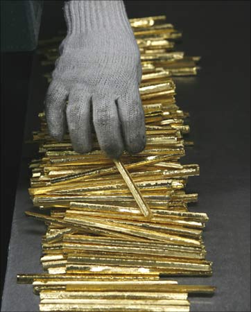 An employee holds gold during processing at the PT Antam Tbk precious metal refinery in Jakarta, Indonesia. | Photograph:  Beawiharta/Reuters