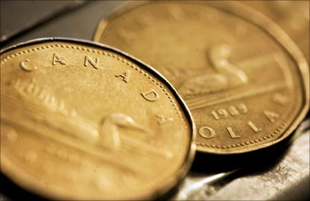 Canadian one dollar coins, also known as loonies, are displayed in Montreal. | Photograph:  Christinne Muschi/Reuters