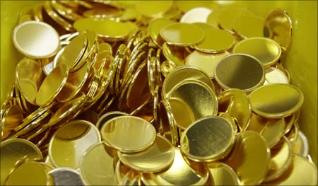 Gold coins production is being cranked up in mints around the world. | Photograph:  Leonhard Foeger/Reuters