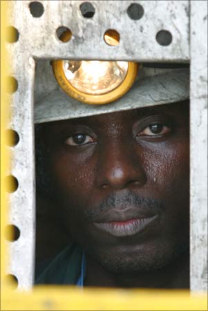 A worker at Ashanti goldfields big mine in Obuasi, Ghana, prepares to go down a lift shaft that extends 5,000 ft underground. | Photograph:  Luc Gnago/Reuters