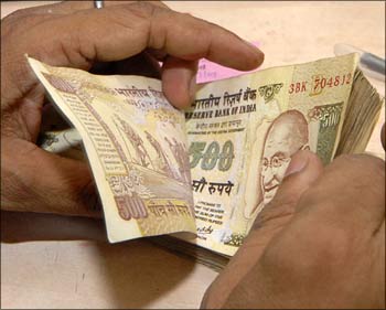 A banker counts Rs 500 notes.
