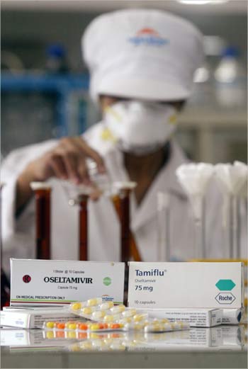 A pharmacy worker conducts research to produce Oseltamivir capsules, a version of Tamiflu.