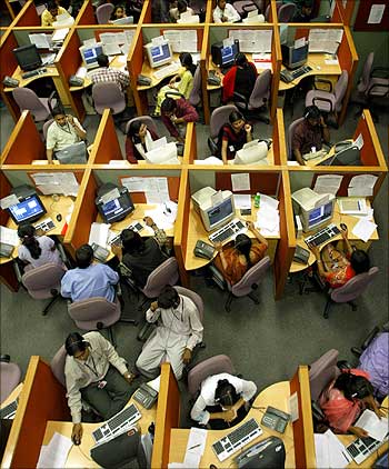 Indian employees seated in their cubicles at a call centre.