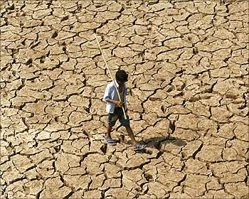 A man walks through the parched banks of Sukhana Lake in Chandigarh.