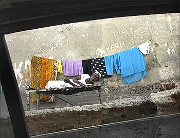 A man sleeps beside the street at a slum in Ahmedabad.