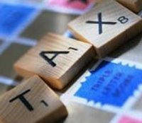 The word tax written on a Scrabble board