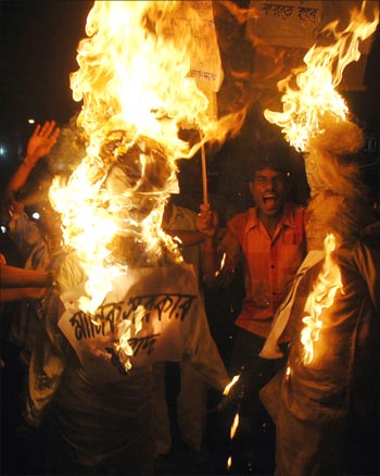 Congress party workers burn effigies.