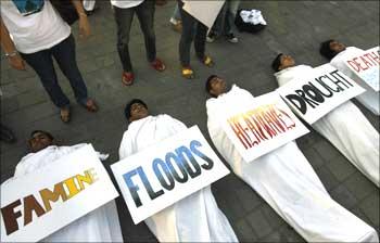 Volunteers pose as dead bodies during an event to create awareness on climate change in Mumbai.