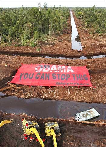 Greenpeace activists display a giant banner during their protest calling on USPresident Barack Obama.