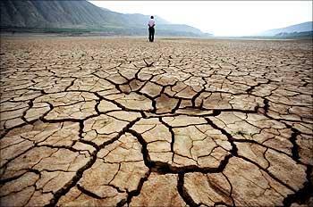 Chinese man walks on a dried-up riverbed at Huangyangchuan reservoir in Lanzhou.