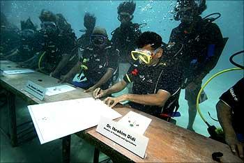 Maldivian Minister of Fisheries and Agriculture Ibrahim Didi signs a declaration.