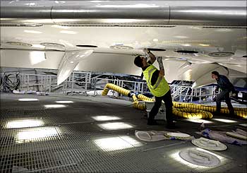 Boeing aircraft maintenance technician Bill Lucyk works on the underside of the first 787 Dreamliner.