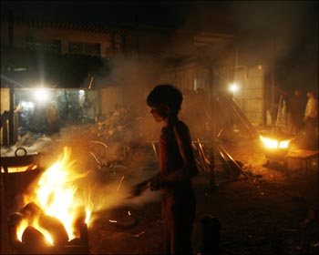 A boy works inside a metal smelting workshop on the outskirts of Mumbai.