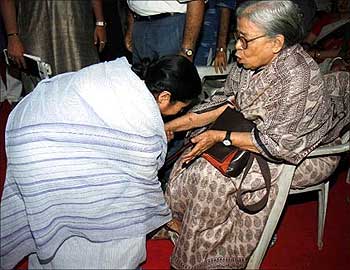 Mamata Banerjee touches Mahasweta Devi's feet.